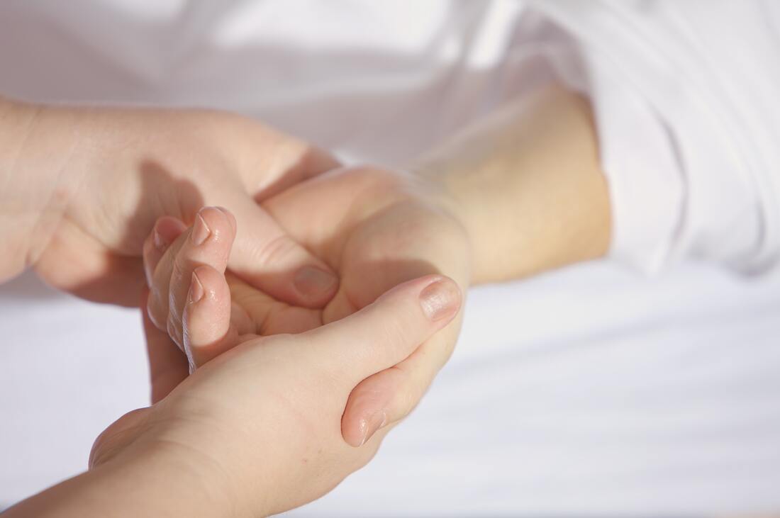 A picture of a person's thumb pressing into another person's palm.